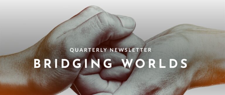 A close up of two hands held together. Over the image, in white text, are the words “Quarterly Newsletter Bridging Worlds”.